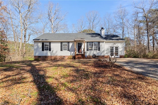 view of front of home featuring crawl space, a chimney, and french doors