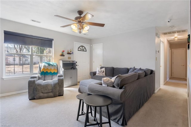 carpeted living room featuring baseboards, visible vents, and a ceiling fan