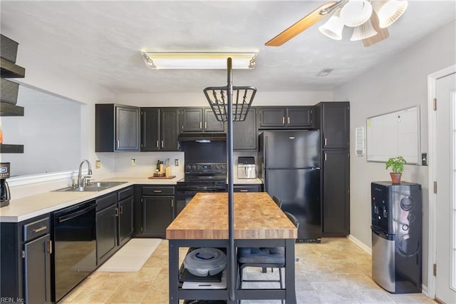 kitchen with under cabinet range hood, light countertops, dark cabinetry, black appliances, and a sink