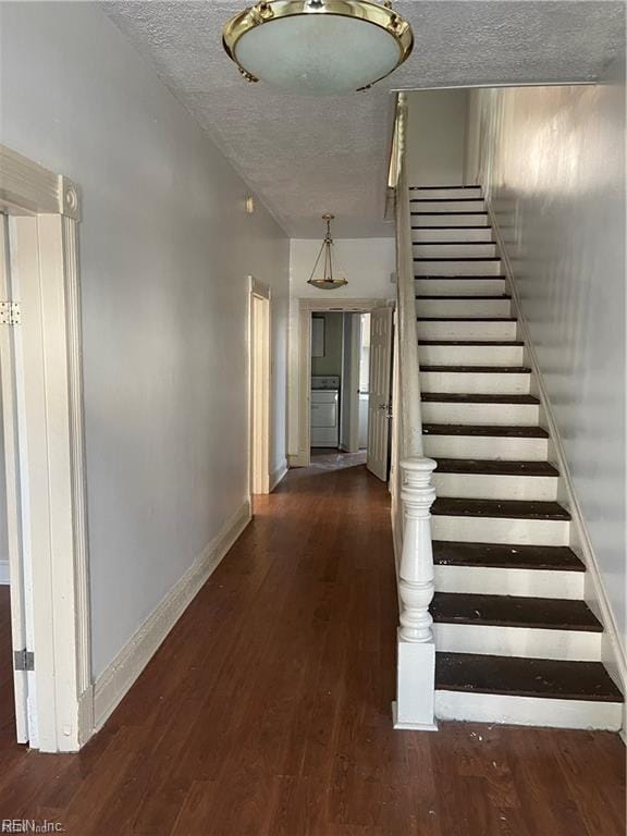 interior space featuring a textured ceiling, baseboards, and wood finished floors