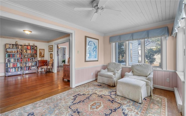 sitting room featuring ornamental molding, wood finished floors, and wainscoting