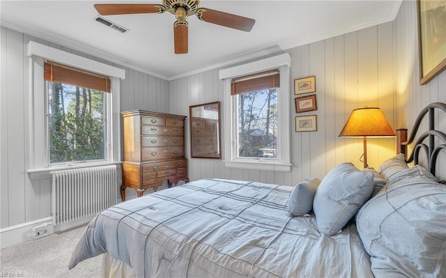 bedroom featuring visible vents, radiator heating unit, ceiling fan, ornamental molding, and carpet flooring