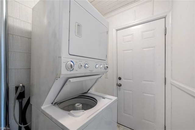 washroom featuring stacked washer / dryer and laundry area