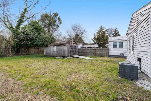 view of yard featuring a storage unit, a fenced backyard, an outdoor structure, and cooling unit