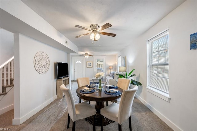 dining space with baseboards, visible vents, stairway, and a ceiling fan