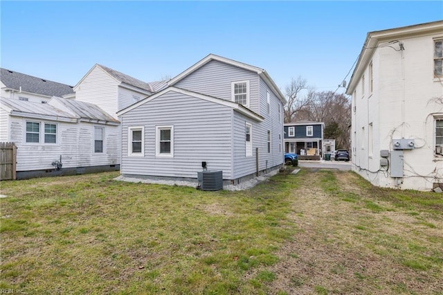 back of property featuring a lawn and central AC unit