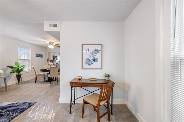 office area featuring carpet floors, baseboards, visible vents, and a ceiling fan