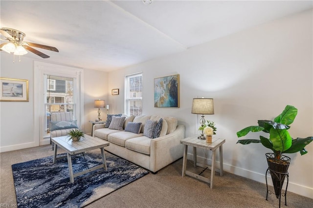 living room featuring ceiling fan, carpet floors, and baseboards