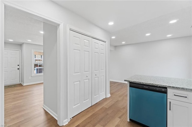 kitchen with recessed lighting, light wood-style flooring, white cabinetry, light stone countertops, and dishwasher