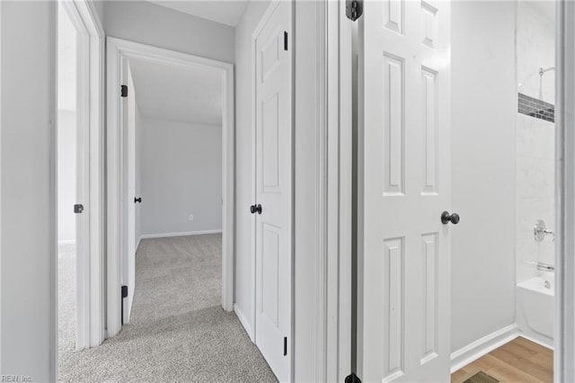 hallway with light carpet and baseboards