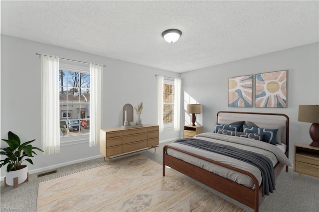 bedroom with multiple windows, baseboards, and a textured ceiling