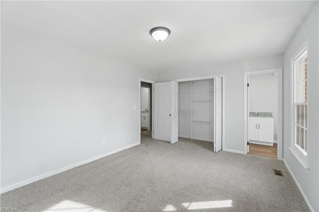 unfurnished bedroom with carpet floors, baseboards, and a closet