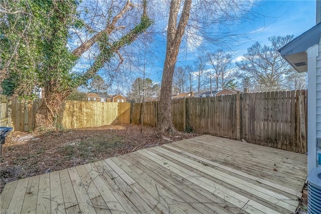 wooden deck with a fenced backyard and central AC unit