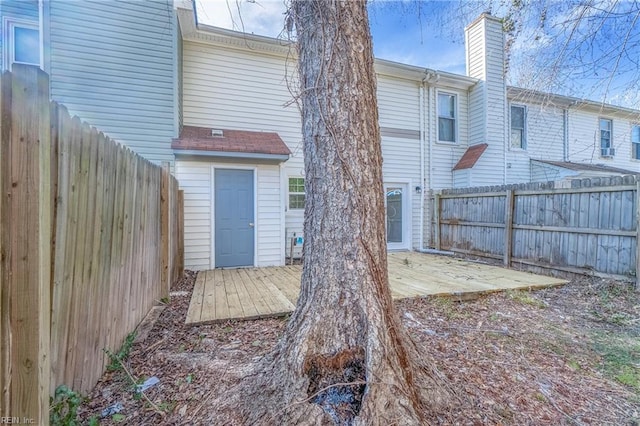 rear view of house featuring a fenced backyard and a wooden deck