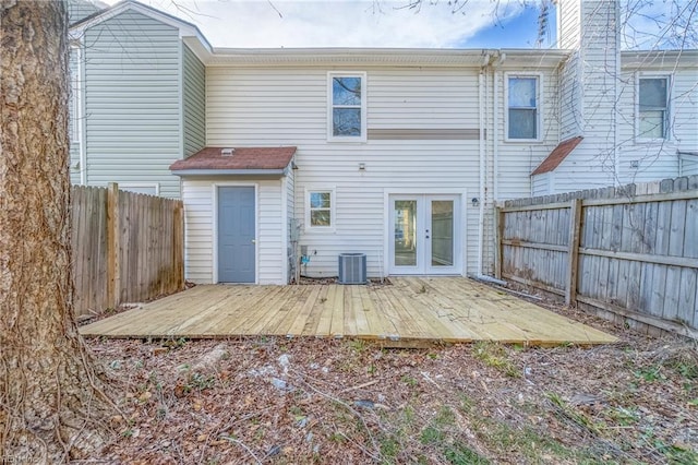 rear view of property featuring a deck, french doors, cooling unit, and a fenced backyard