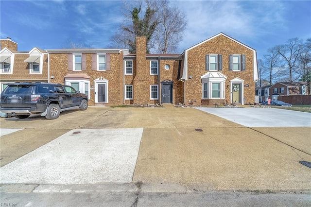 view of property with a chimney and brick siding