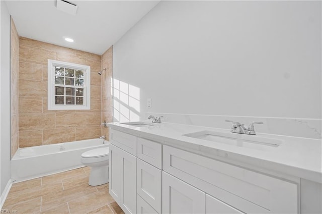 full bathroom featuring double vanity, shower / bath combination, a sink, and toilet