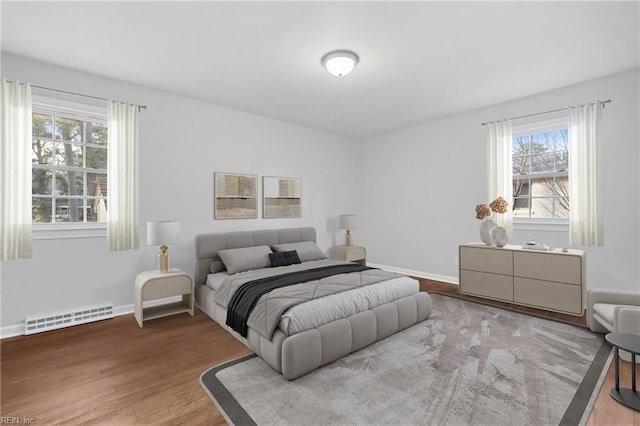 bedroom featuring visible vents, baseboards, and wood finished floors