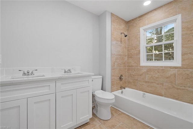 bathroom featuring a sink, shower / bathing tub combination, toilet, and double vanity