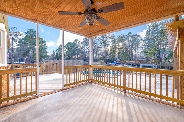 unfurnished sunroom featuring ceiling fan and wood ceiling