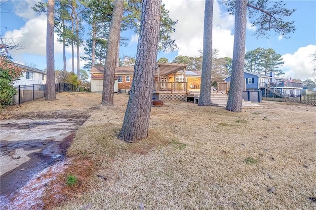 view of yard featuring a wooden deck and fence