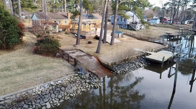 exterior space featuring a residential view, a water view, and a dock