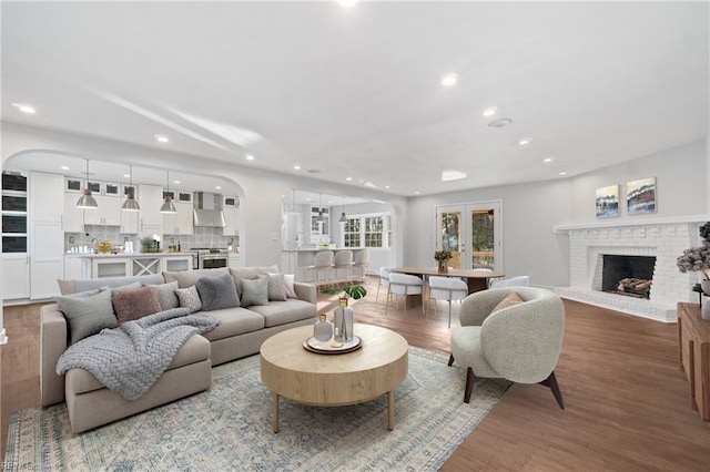 living area featuring recessed lighting, a fireplace, and wood finished floors