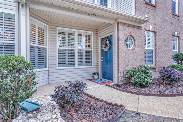 view of exterior entry with brick siding