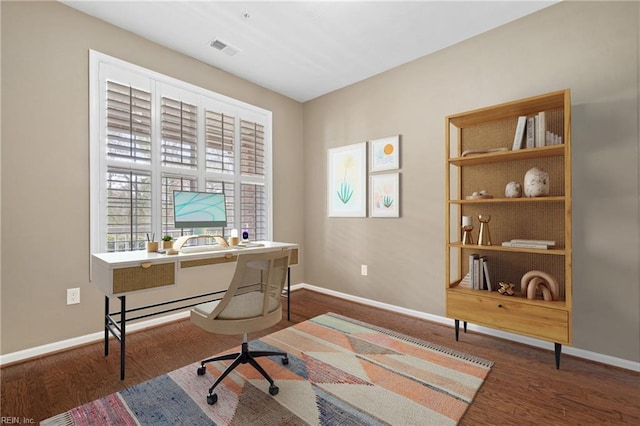 office featuring built in shelves, visible vents, baseboards, and wood finished floors