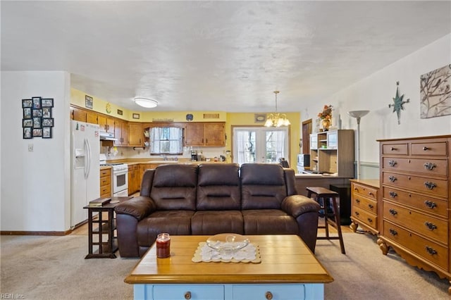 living area with light carpet, a notable chandelier, and baseboards