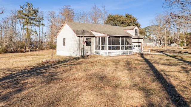 exterior space featuring a front lawn, crawl space, an attached garage, and a sunroom