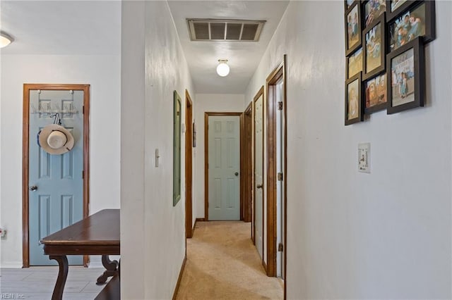 hall with light carpet and visible vents