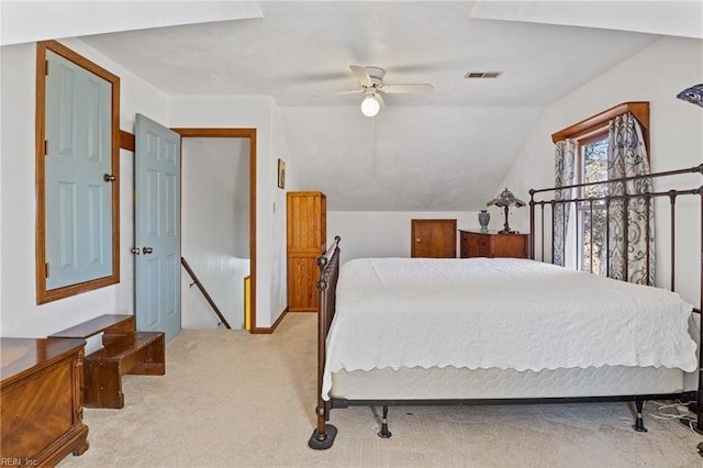 bedroom with carpet floors, ceiling fan, visible vents, and vaulted ceiling