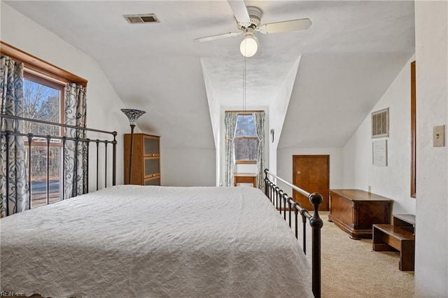 carpeted bedroom featuring lofted ceiling, visible vents, and a ceiling fan