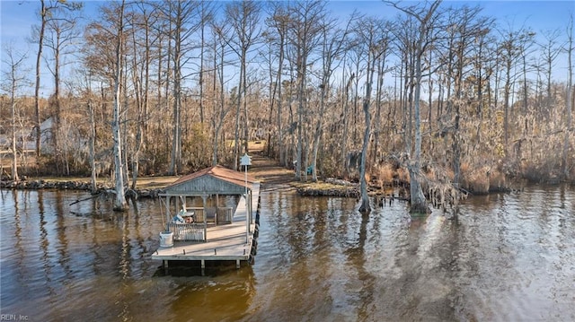 view of dock with a water view and a wooded view