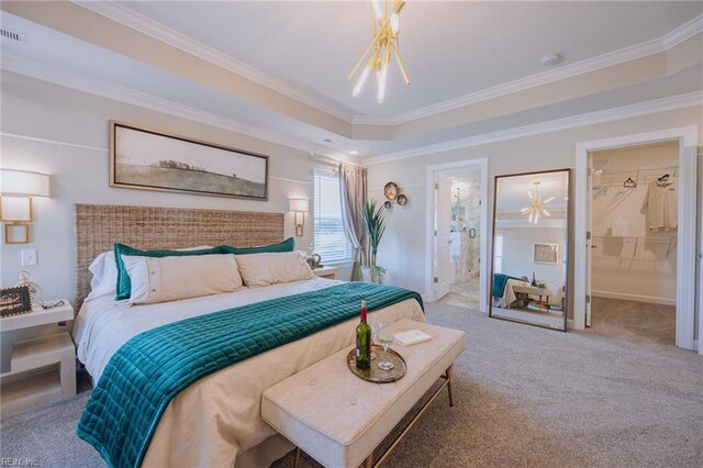 bedroom with carpet floors, crown molding, a raised ceiling, visible vents, and ensuite bathroom