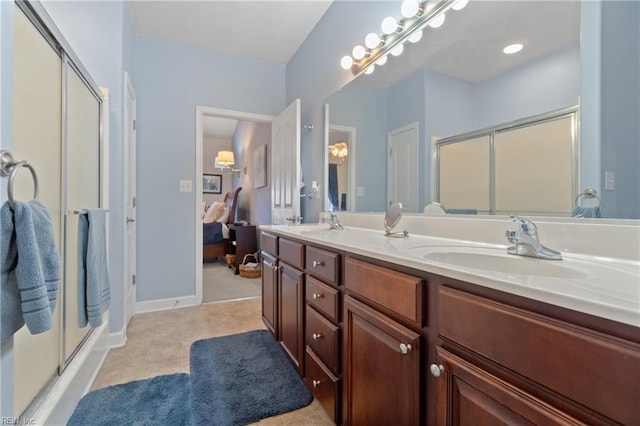 bathroom featuring double vanity, ensuite bathroom, a sink, a shower stall, and tile patterned floors