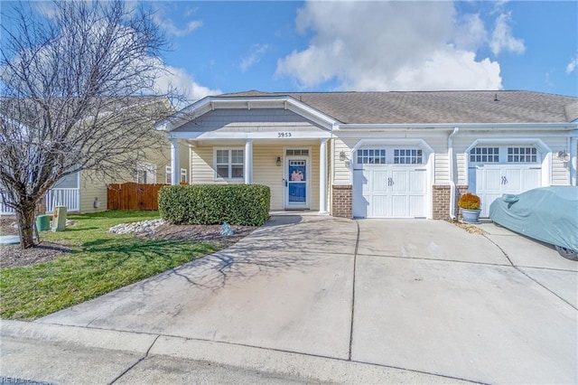 view of front of property featuring concrete driveway, brick siding, fence, and an attached garage