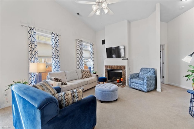 carpeted living room featuring high vaulted ceiling, a high end fireplace, visible vents, and baseboards