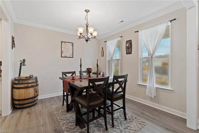 dining room with baseboards, ornamental molding, and wood finished floors