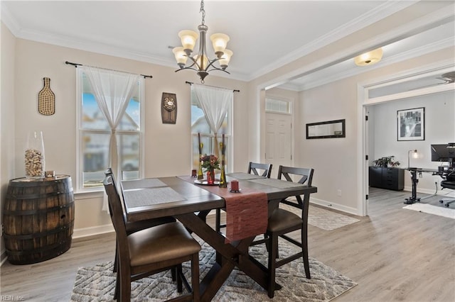 dining area with ornamental molding, light wood-type flooring, a chandelier, and baseboards