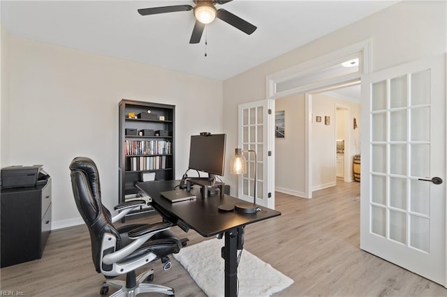 office space featuring baseboards, french doors, a ceiling fan, and light wood-style floors