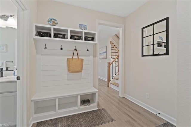 mudroom featuring light wood-style flooring and baseboards