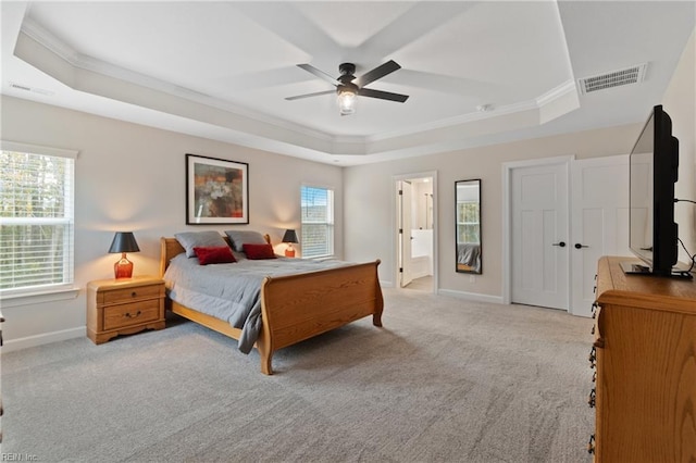 bedroom with a tray ceiling and visible vents