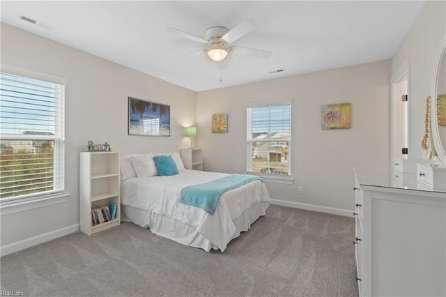 carpeted bedroom featuring baseboards, visible vents, and ceiling fan