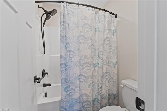 bathroom featuring shower / bath combo with shower curtain and toilet