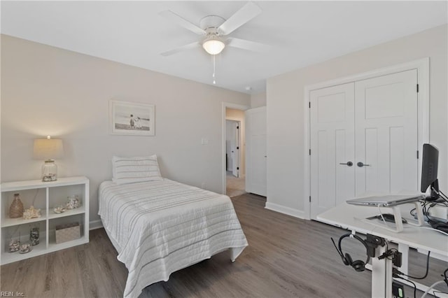 bedroom featuring a closet, ceiling fan, baseboards, and wood finished floors