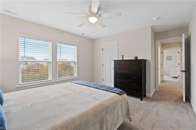 bedroom featuring attic access, visible vents, baseboards, a ceiling fan, and light colored carpet