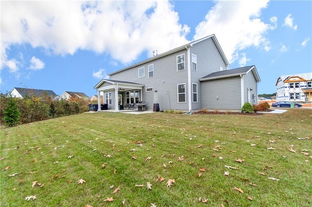 back of property featuring a patio and a lawn