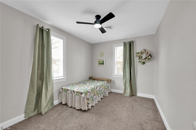 carpeted bedroom with ceiling fan, visible vents, and baseboards